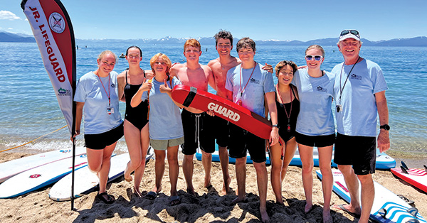 lifeguard coaches smile with lake tahoe behind them