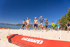 teens run on beach at lifeguard camp