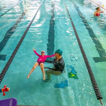 youth swim lesson girl in pool with instructor