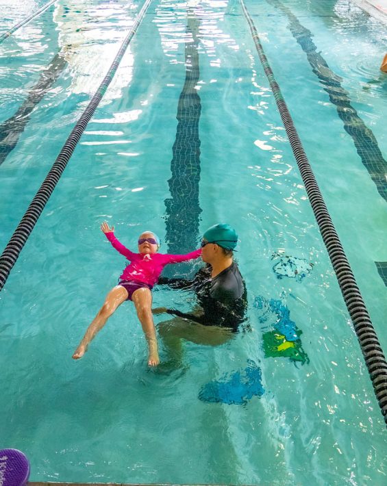 youth swim lesson girl in pool with instructor