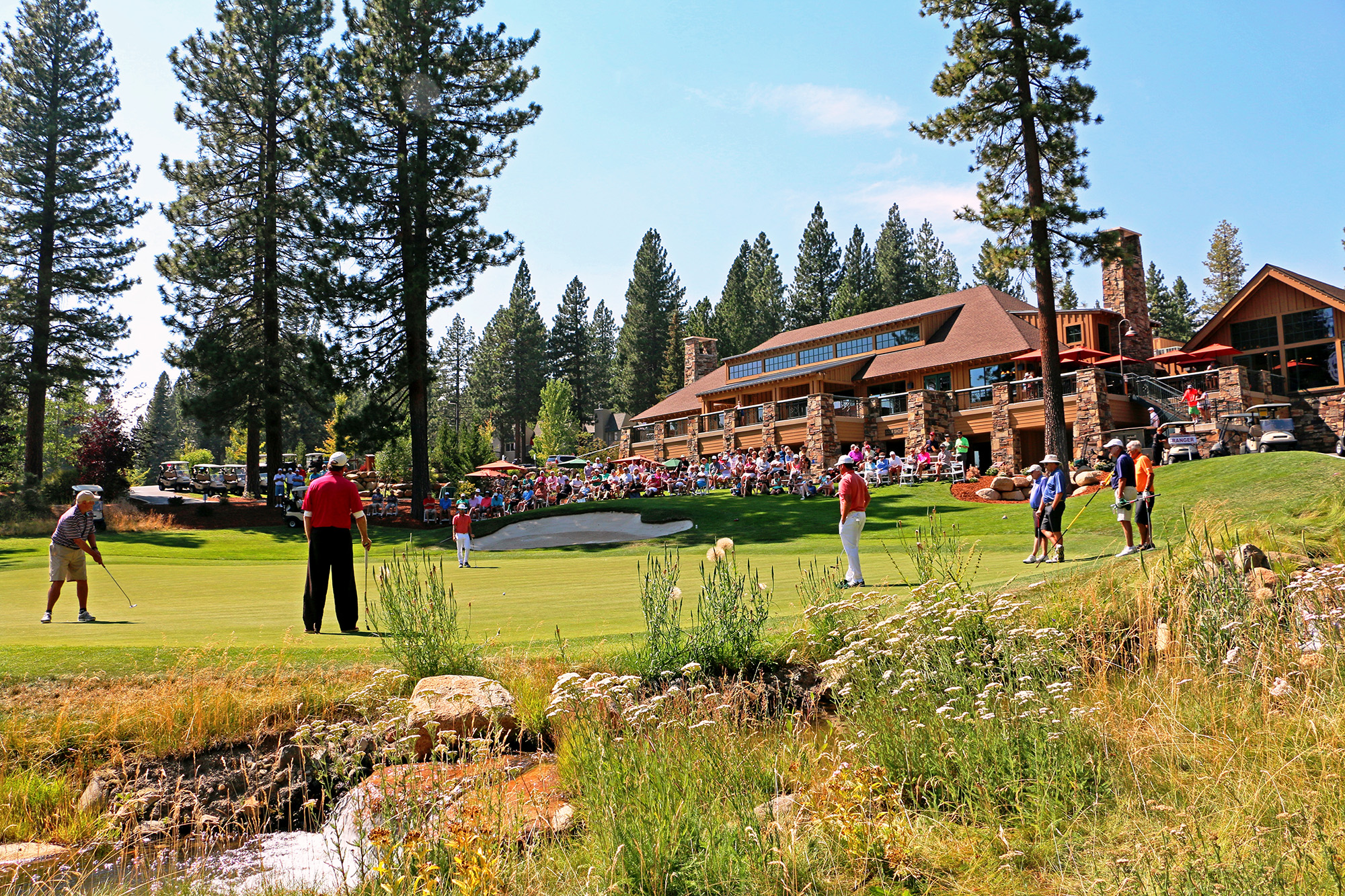 crowd watches golfers during a tournament
