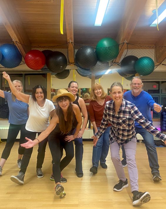line dancers pose in group fitness room