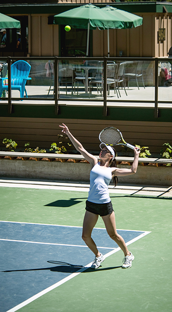 A woman serves in a tennis match