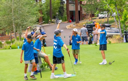 junior golf league players on practice green