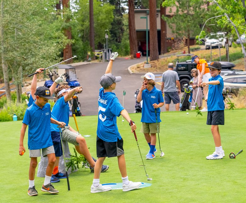 junior golf league players on practice green