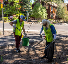two women picking up trash