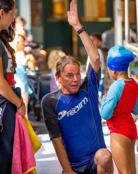 swim lesson male instructor gives instruction on pool deck