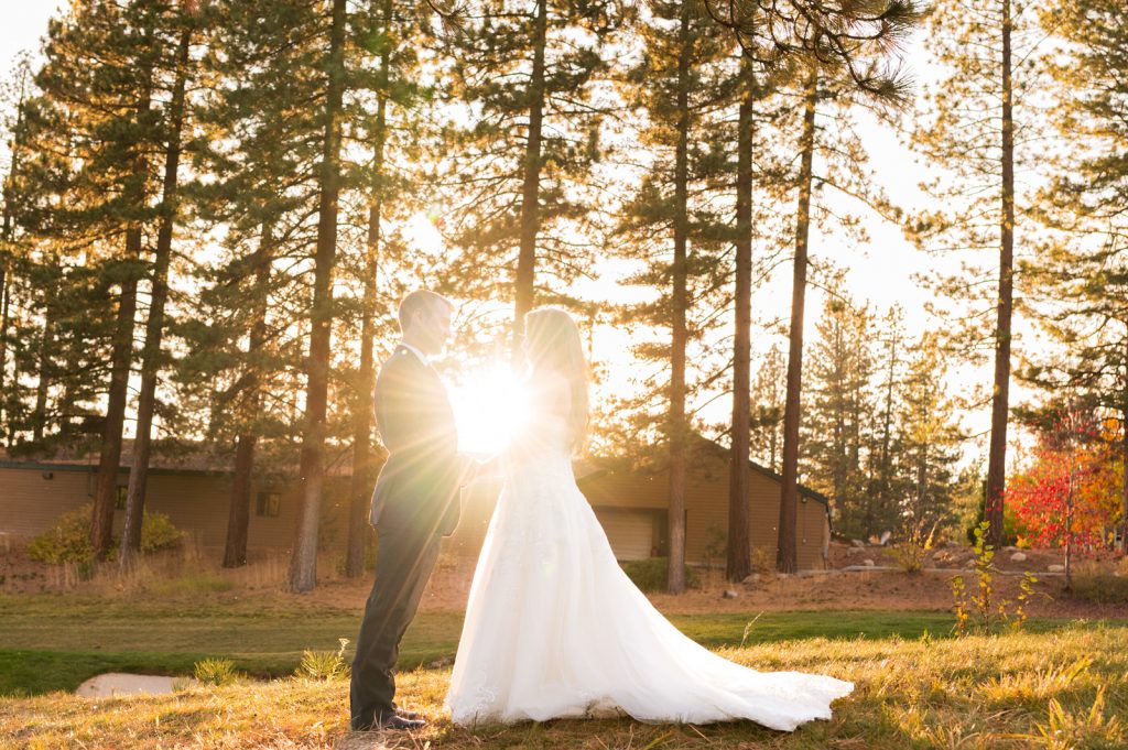 bride and groom with sun behind them