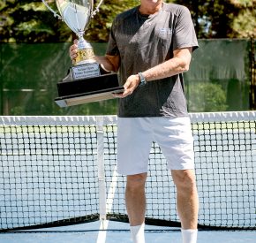 man holding tennis trophy