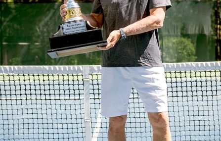 man holding tennis trophy