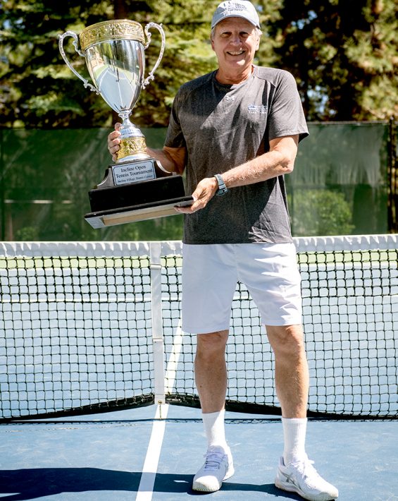 man holding tennis trophy