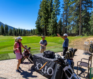 woman and man with club fitter at the range
