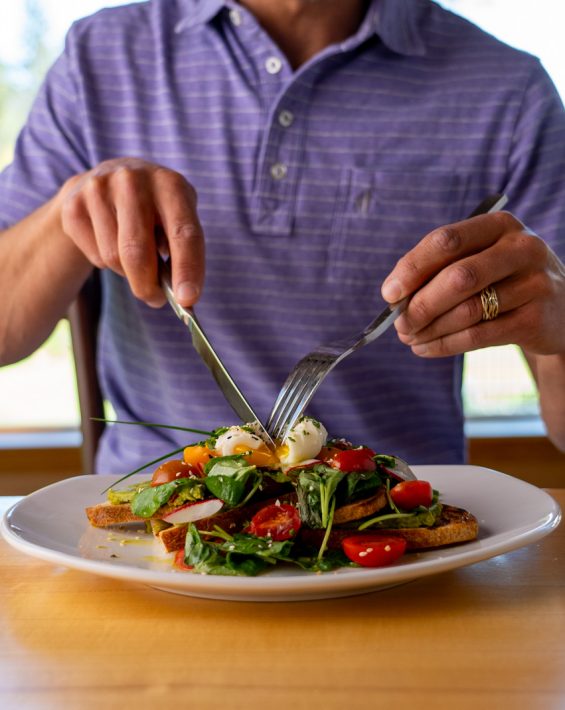 man cuts poached egg at The Grille