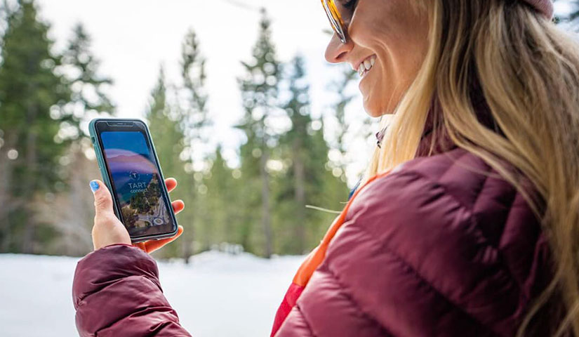 woman holding phone with tart connect app