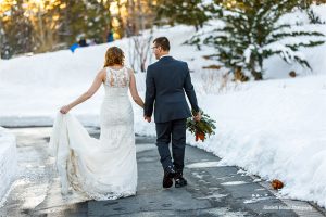 winter wedding couple holds hands