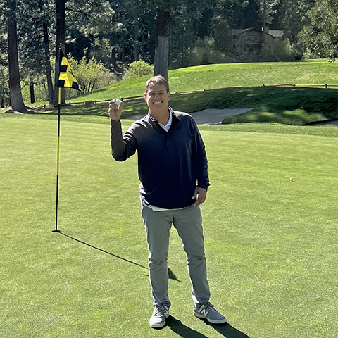 man holding ball after hole in one