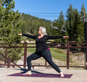woman in warrior yoga pose on the deck at diamond peak