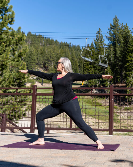 woman in warrior yoga pose on the deck at diamond peak