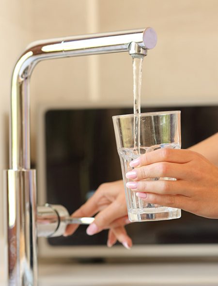 Tap water pouring into a glass