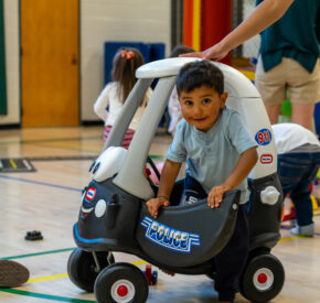 boy playing ride on toy at preschool playground