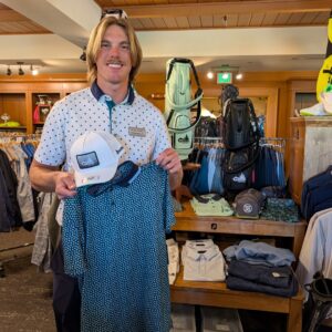 golf shop merchandise staff dads and grads pick dalton holds up hat and polo