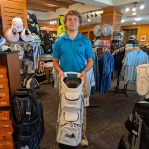 golf shop merchandise staff dads and grads pick james with a golf bag