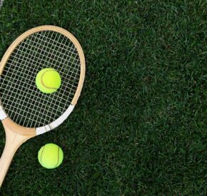 Wooden tennis racket on grass court