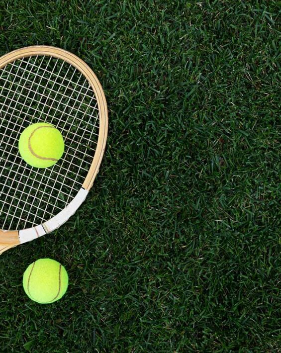 Wooden tennis racket on grass court