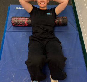 Woman laying on back on foam roller stretching