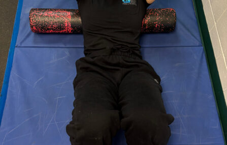 Woman laying on back on foam roller stretching