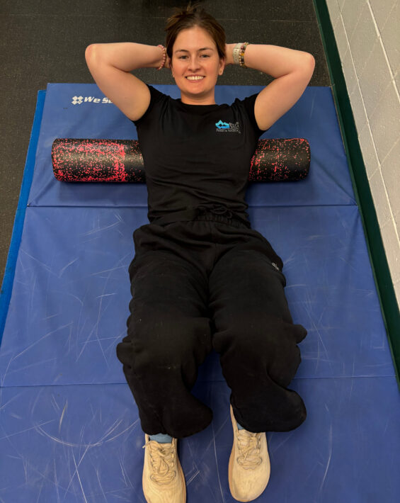 Woman laying on back on foam roller stretching