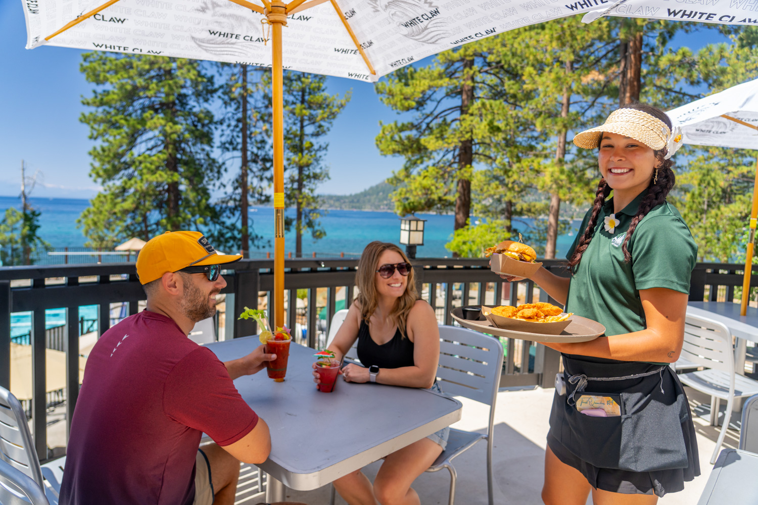 burnt cedar beach server hands food to a couple
