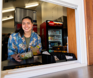 server with salad and cocktail in snack bar window
