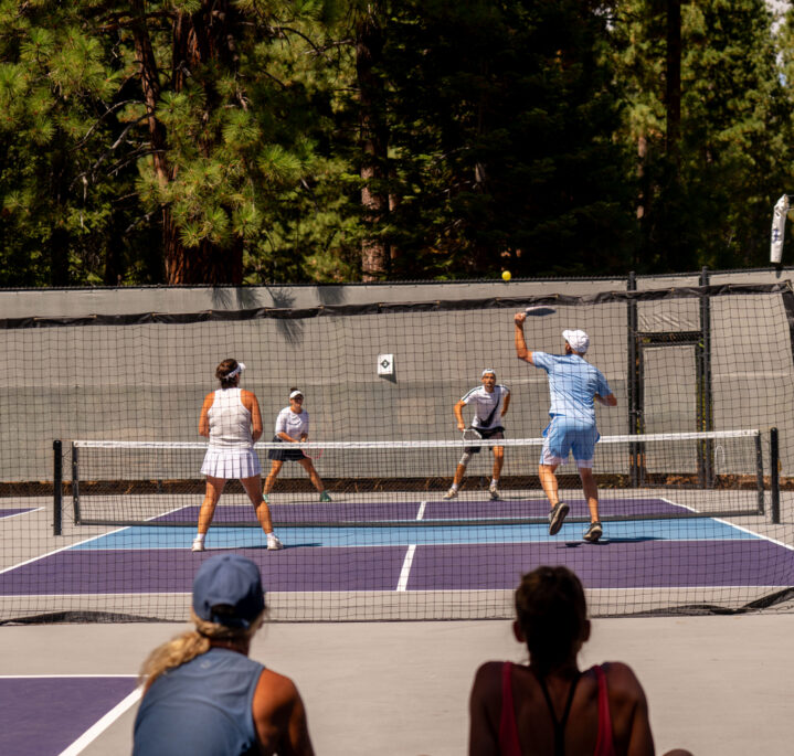 women watch pickleball match